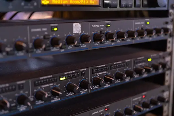 AV technician configuring a digital signal processor in an equipment rack