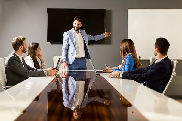 A business leader speaking naturally in a meeting room without handling AV controls