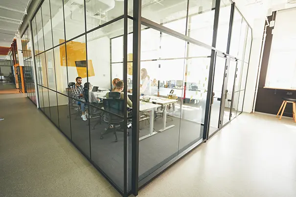 Glass-walled conference room with hard reflective surfaces that increase reverberation