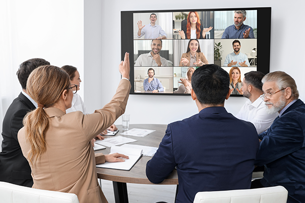 Hybrid meeting in progress with remote participants clearly visible on screen alongside in-room colleagues