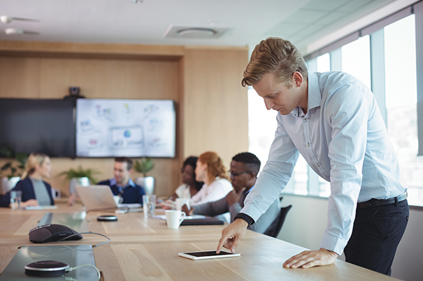 IT manager reviewing a conference room's technology and layout as part of an AV experience audit
