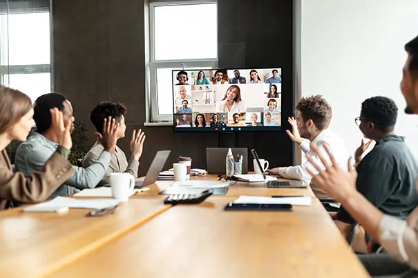 Team in a large hybrid meeting with remote colleagues on screen